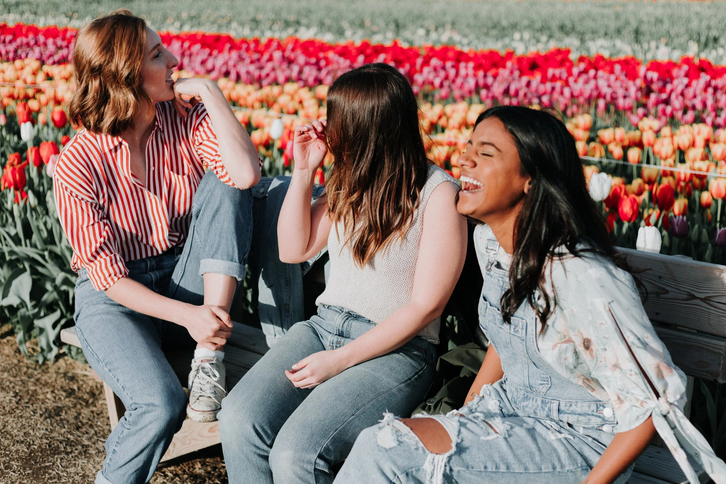 Three young women laughing together outdoors
